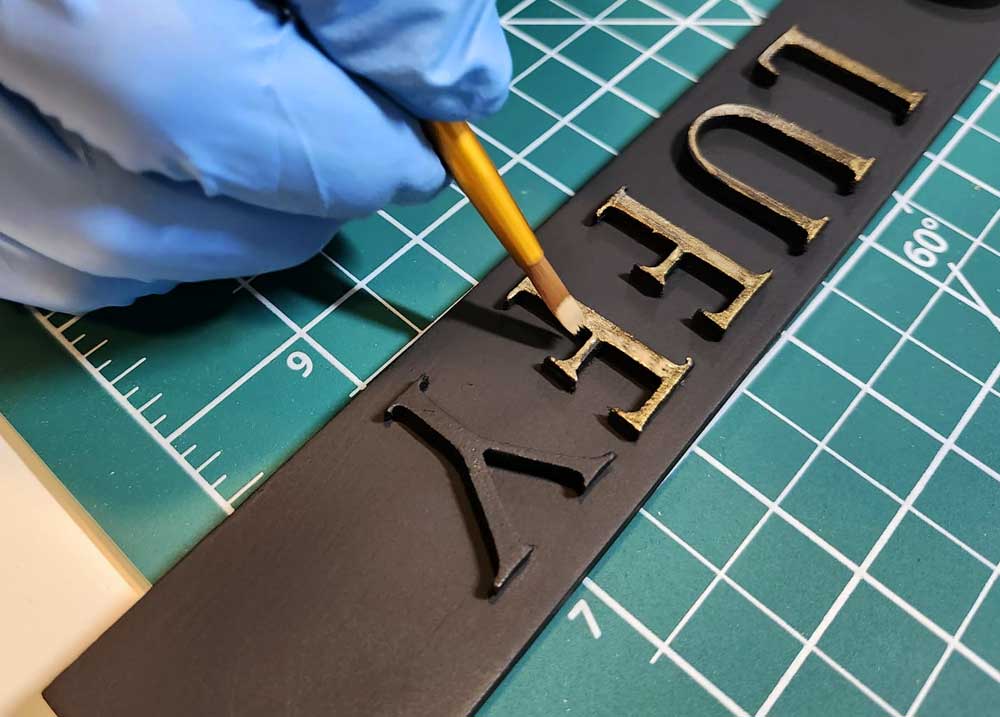 Hand-painting-custom-display-case-lettering-for-a-diorama-for-action-figures Hand-painting custom display case lettering for a diorama for action figures